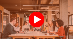 Bright open concept office. There is a work meeting being held where a group of diverse people, including a man on a wheelchair are working together. |