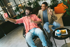 Deux hommes en fauteuil roulant prenant un selfie.