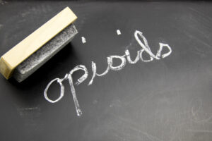 Opioid written in chalk on blackboaard with an eraser.