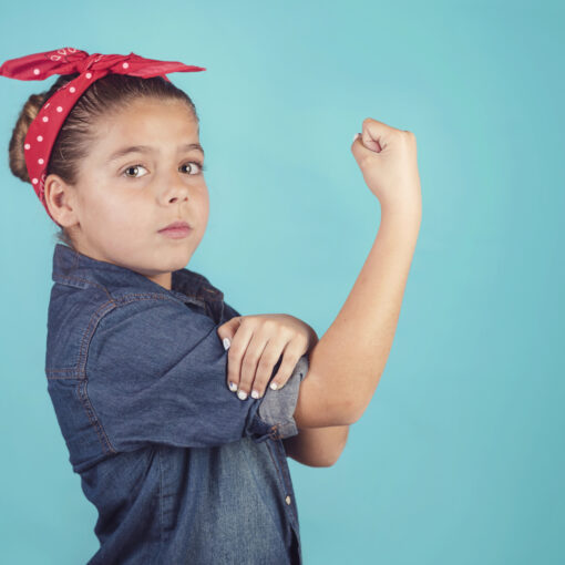 Child dressed as Rosie the Riveter on blue background