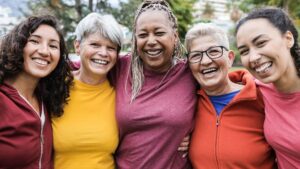 Happy multi generational women having fun together - Multiracial friends smiling on camera after sport workout outdoor - Main focus on african female face