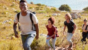 Un groupe de jeunes randonneurs se promenant sur un sentier montagneux par une journée ensoleillée