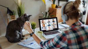 A man on a virtual call pets his cat.