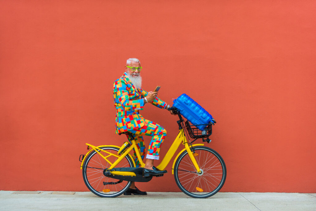 Hipster senior man on bicycle with extravagant style portrait