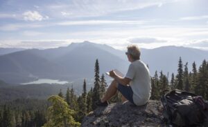 Man sitting outdoors writing in journal