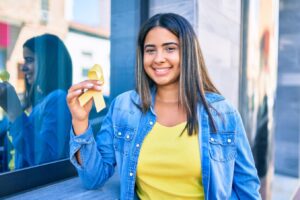 Une jeune femme tenant un ruban jaune devant une fenêtre.