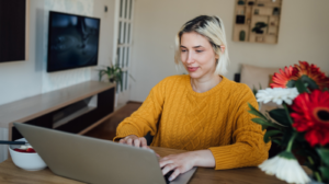 Une femme, à la maison, utilisant un ordinateur portable