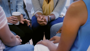 People in a circle with clasped hands
