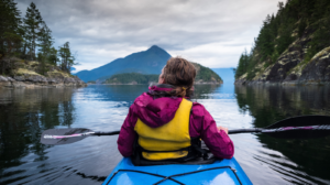 une femme en kayak profitant de la nature sur un lac immobile