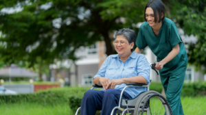 Un prestataire de soins appréciant une conversation avec une personne âgée en fauteuil roulant