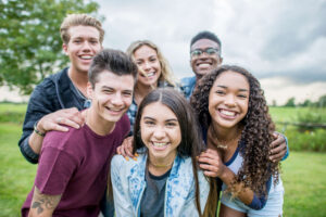 A group of people in a park, smiling at the camera.