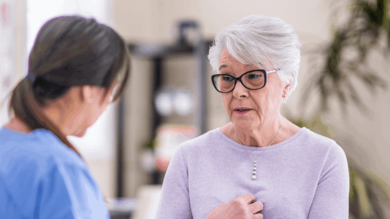 An elderly person speaks with their doctor