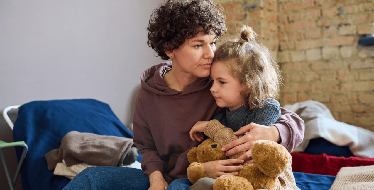 A woman comforting her daughter at a shelter
