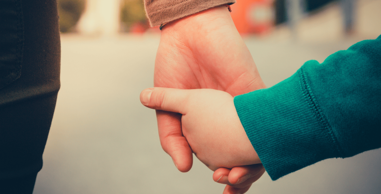 A mother and child holding hands