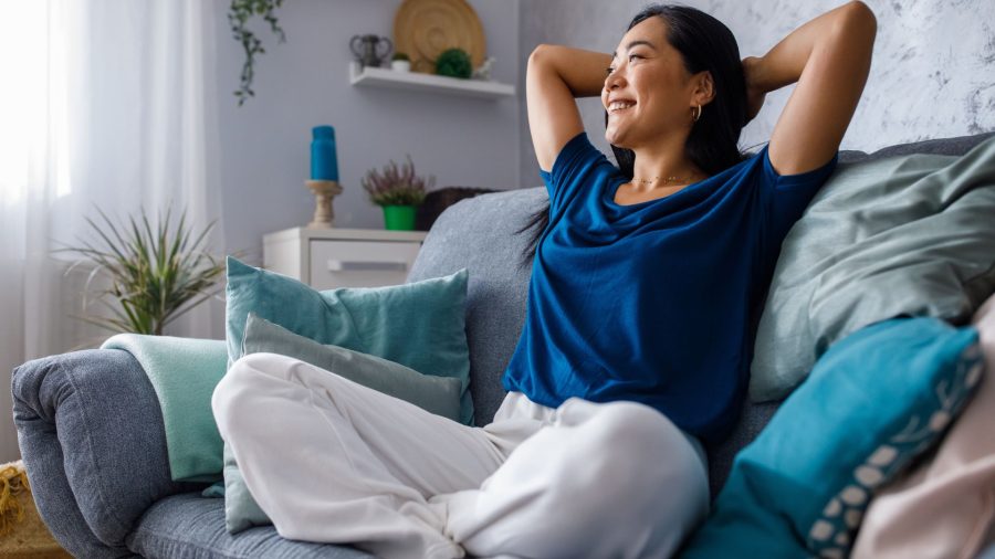 Une femme est assise sur un canapé dans son salon.